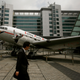 A man walks past a replica of a DC3 passenger plane, one of the first two planes used by Cathay Pacific Airways when it started its operations in 1946.